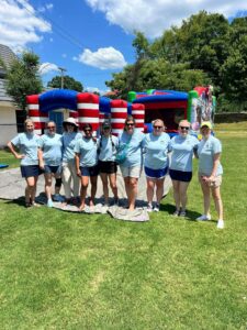 JA Volunteers for Summer Splash in Front of Bounce House